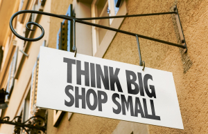 Schild auf dem steht: Think Big, Shop Small | AUSGEZEICHNET.ORG
