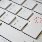 Der richtige Umgang mit negativen Kundenfeedback Tastatur auf der ein Daumen nach unten zeigt zur Visualisierung zum Umgang mit negativen Kundenfeedback
