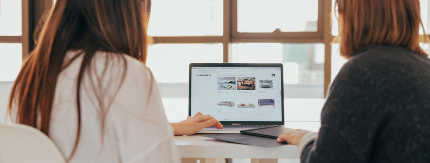 Ausgezeichnet.org erklärt das Konzept von Content-Syndication und verweist auf die Vermeidung von Duplicate Content, das Bild zeigt zwei Personen am Laptop