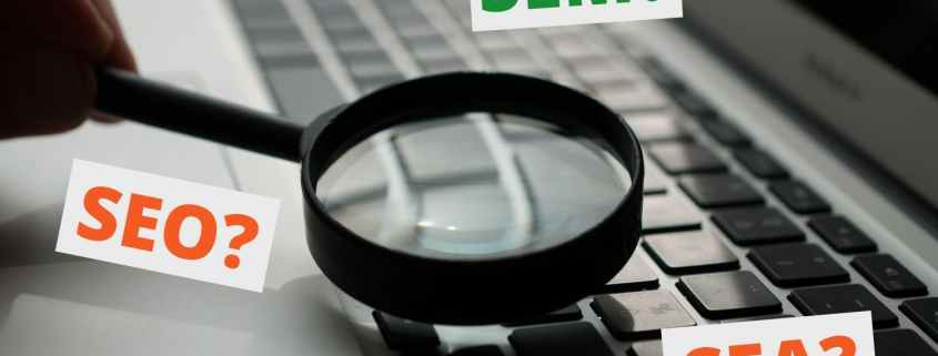 Ausgezeichnet.org erläutert die Begriffe Search Engine Optimization, Search Engine Advertising and Search Engine Marketing und grenzt diese ab, das Bild zeigt eine Laptoptastatur und eine Lupe und die Wörter SEM, SEO und SEA sind zu sehen