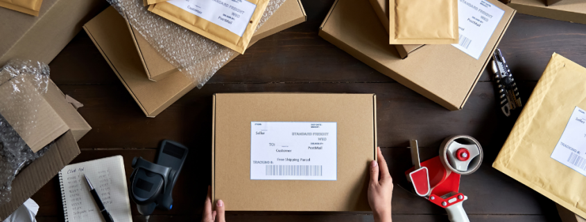 Hand hält Paket auf Tisch | AUSGEZEICHNET.ORG