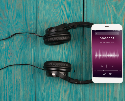 Handy mit Podcast liegt auf Kopfhörern | AUSGEZEICHNET.ORG
