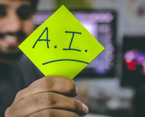 Ein mann hält ein Schild mit den Schriftzug AI in der Hand für künstliche Intelligenz