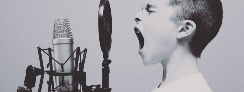 Junge der ins Mikrofon brüllt